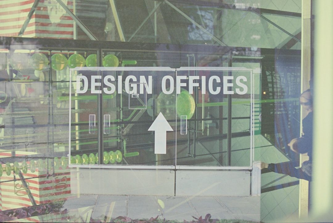 A glass door with white text reading DESIGN OFFICES and an upward arrow.